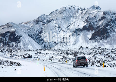 Suzuki Vitara Fahrzeug, das im Februar in Island durch schneebedeckte Berge und Tundra fuhr, sieht aus wie eine Holzkohlenzeichnung Stockfoto