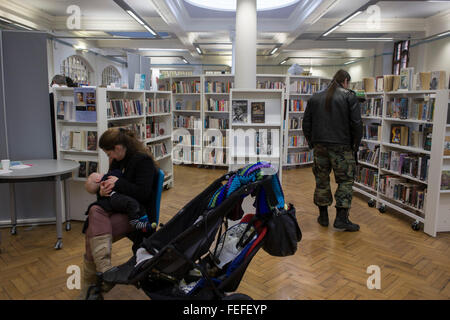 Eine stillende Mutter in Carnegie-Bibliothek, Herne Hill, Süd-London. Konfrontiert mit der Schließung seiner geliebten lokalen Bibliothek, Lambeth Rates Plan, in der Nähe der Anlage wird von der Gemeinschaft im Rahmen der Sparmaßnahmen, die sagen, dass sie das Gebäude in ein Fitness-Studio privatey betriebenen gentrifizierten Geschäfte - anstatt vielgeliebten und Lesezimmer Lernressource konvertiert werden. £12.600 wurde von der amerikanischen Philanthrop Andrew Carnegie zum Aufbau die Bibliothek im Jahre 1906 eröffneten gestiftet. Es ist ein schönes Beispiel von Edwardian bürgerlichen Architektur, mit roten Flettan Ziegeln gebaut und Terrakotta, als Grade II in Stockfoto