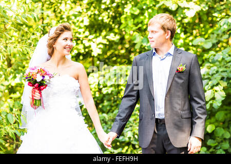 Braut und Bräutigam Hand in Hand im freien Stockfoto
