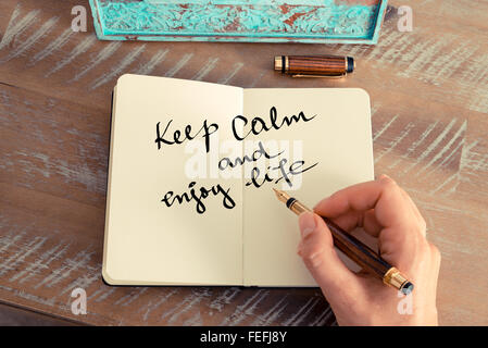 Retro-Effekt und getönten Bild einer Frau hand schreiben eine Notiz mit einem Füllfederhalter auf einem Notebook. Stockfoto