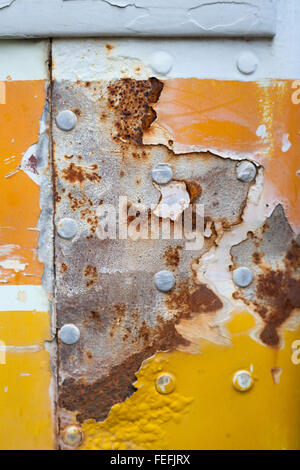 Orange und gelb malen abgenutzt, alt und rostig und verkratzte Metall strukturiert durch die Zeit. Stockfoto