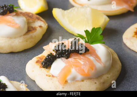 Blinis mit Kaviar und Lachs auf Tisch Stockfoto