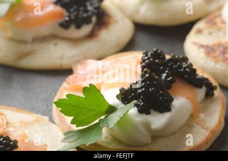 Blinis mit Kaviar und Lachs auf Tisch Stockfoto