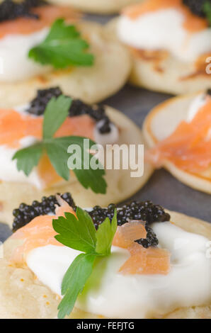 Blinis mit Kaviar und Lachs auf Tisch Stockfoto