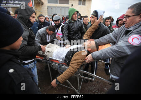 Jenin, Westjordanland, Palästinensische Gebiete. 6. Februar 2016. Ein palästinensischen Demonstranten wird ausgeführt, um seinen verletzten Kameraden bei Zusammenstößen mit israelischen Sicherheitskräften in das Dorf Kabatije, in der Nähe der Stadt Jenin im Westjordanland, bei Zusammenstößen auf 6. Februar 2016 zu helfen. Drei Palästinenser aus Kabatije griffen israelische Polizei mit Pistolen und Messern außerhalb der Jerusalemer Altstadt, am 3. Februar eine Polizistin tötete und verletzte einen anderen bevor Sie erschossen DeadPhoto von Nedal Eshtayah © Nedal Eshtayah/APA Bilder/ZUMA Draht/Alamy Live News Stockfoto