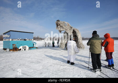 Minneapolis, Minnesota, USA. 6. Februar 2016. Eine Frau in einem Bär Kostüm spricht mit zwei Personen auf Skiern in der Nähe der Matoska Tonka Shuttle tragen Shanty, eines der Kunst Shanties auf Shanty Kunstprojekte auf gefrorenen White Bear Lake, außerhalb von Minneapolis, Minnesota, USA, 6. Februar 2016. Bildnachweis: Gina Kelly/Alamy Live-Nachrichten Stockfoto