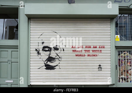 Ein Auge für ein Auge macht die ganze Welt blind, Zitat von Gandhi als Graffiti auf einer Shop-Auslöser. Stockfoto