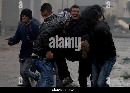 Jenin, West Bank. 6. Februar 2016. Palästinensische Demonstranten helfen einen verletzten Kameraden bei Zusammenstößen mit israelischen Sicherheitskräften in das Dorf Kabatije, in der Nähe der Stadt Jenin im Westjordanland. Drei Palästinenser aus Kabatije griffen israelische Polizei mit Pistolen und Messern außerhalb der Jerusalemer Altstadt, am 3. Februar eine Polizistin tötete und verletzte einen anderen vor wird erschossen. © Nedal Eshtayah/APA-Images/ZUMA Draht/Alamy Live News Stockfoto