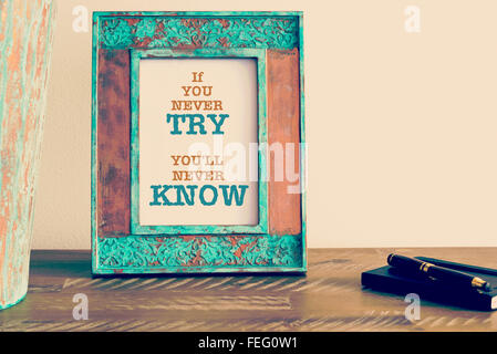 Retro-Wirkung und getönten Bild einen Vintage Bilderrahmen mit motivierenden Zitat neben Füllfederhalter und notebook Stockfoto