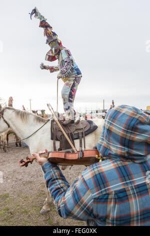 LeJeune Cove, Louisiana, USA. 6. Februar 2016. Ein Cajun Karneval Zecher tanzt mit einem Spielmann während auf dem Rücken der Pferde während der LeJeune Cove Courir de Karneval 6. Februar 2016 im Iota, Louisiana. Nachtschwärmer toben durch die Landschaft verursachen Unfug und betteln dann feiern, indem Sie tanzen. Bildnachweis: Planetpix/Alamy Live-Nachrichten Stockfoto