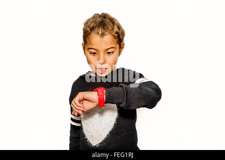 Acht Jahre altes Mädchen auf der Suche auf ihre Uhr überrascht, wie es spät ist Stockfoto