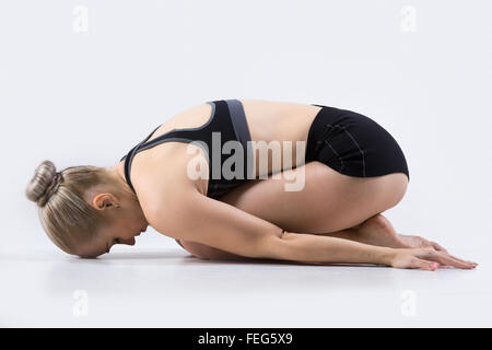 Sportlich schöne junge Frau, Yoga zu praktizieren, Balasana, Kind darstellen, stärkende Übungen zum Stressabbau zu tun, arbeiten Stockfoto