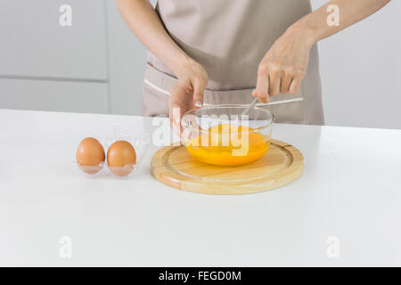Koch schlagen von Eiern in einer Schüssel zu Schokoladenkuchen Stockfoto