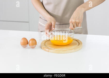 Koch schlagen von Eiern in einer Schüssel zu Schokoladenkuchen Stockfoto
