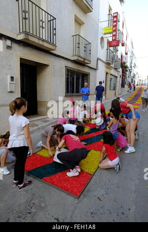 Fronleichnam. Die Dorfbewohner legen am Gründonnerstag traditionelle Teppiche aus farbigem Sägemehl auf ihre Straße. Carcabuey, Andalusien, Spanien Stockfoto