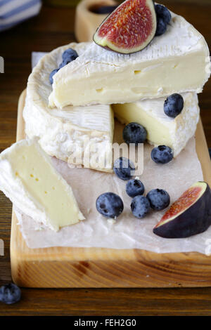 Camembert Käse mit Feigen und Heidelbeeren an Bord Stockfoto