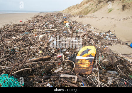 07. Februar 2016. Schockierende Menge Plastik und Treibholz, die am Strand von Pembrey Sands, Carmarthenshire, Wales, britischen Delfinen, Surfbrett, Stockfoto