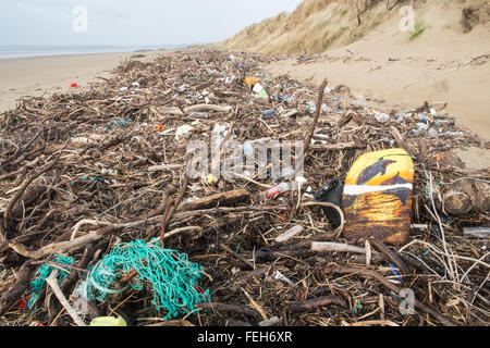 07. Februar 2016. Schockierende Menge Plastik und Treibholz, die am Strand von Pembrey Sands, Carmarthenshire, Wales, britischen Delfinen, Surfbrett, Stockfoto