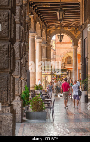 Bologna Arcade, Aussicht auf ein sommermorgen von Menschen zu Fuß unter einer grossen Renaissance Portikus in der Via Francesco Rizzoli, Zentrum von Bologna, Italien. Stockfoto