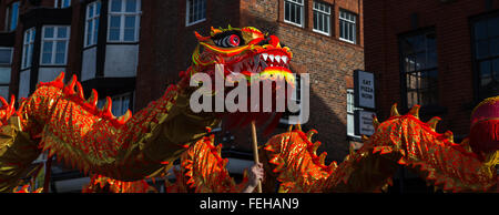 Die lebendige orange farbige Drachen gesehen tanzen um die Hauptstraßen, die Chinatown Liverpools ausmachen. Stockfoto