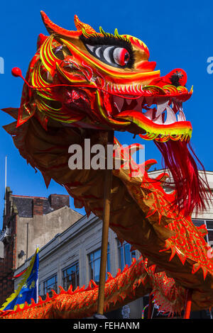 Die lebendige orange farbige Drachen gesehen tanzen um die Hauptstraßen, die Chinatown Liverpools ausmachen. Stockfoto