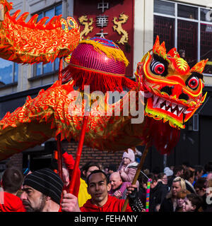 Die lebendige orange farbige Drachen gesehen tanzen um die Hauptstraßen, die Chinatown Liverpools ausmachen. Stockfoto