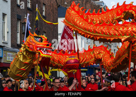 Die lebendige orange farbige Drachen gesehen tanzen um die Hauptstraßen, die Chinatown Liverpools ausmachen. Stockfoto