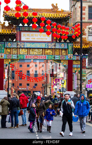 Chinesischer Kaiserbogen mit Skulpturen. Dieser große imperiale Torbogen, ein offizielles Geschenk aus Peking, ist das imposante Tor zu Manchesters Chinatown und der einzige seiner Art in Europa. Es enthält 200 handgeschnitzte Drachen, die den Eingang zu Chinatown markieren, Buddhas-Statuen an der Fassade des Gebäudes Hall of the Sea of Wisdom in Manchester, Großbritannien Stockfoto