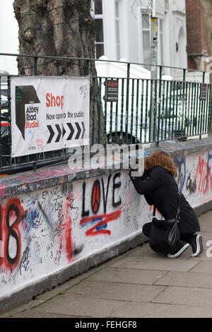 Frau, die Schrift an der Wand außerhalb der Londoner Abbey Road Studios Stockfoto