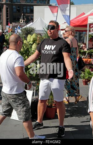 Mit verbundenen Augen Mann mit einem T-shirt sagen "HIV positiv" & ein Schild mit der Aufschrift "Free HIV Umarmungen" in Helsinki, Finnland.