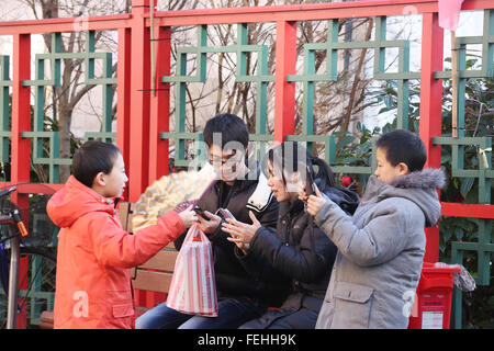 Manchester, UK 7. Februar 2016 eine Familie mit Technologie zusammen in Chinatown Credit: Barbara Koch/Alamy Live News Stockfoto