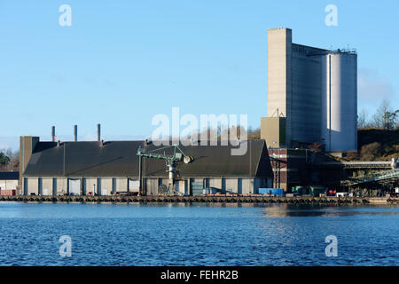 Karlshamn, Schweden - 4. Februar 2016: Ein Industriegebiet im Hafen von Karlshamn. Hier ist eine alte Lagerhalle mit einem cra Stockfoto