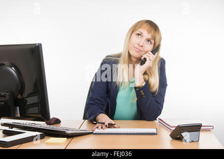 Junge Frau Sekretärin sitzt am Schreibtisch arbeiten, isoliert auf weißem Hintergrund Stockfoto