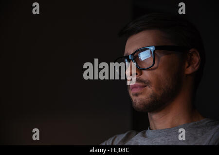 Porträt von hübscher junger Mann in Gläsern auf Bildschirm Stockfoto