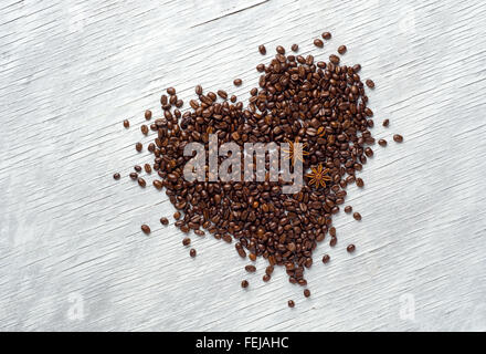 Herzform aus Kaffeebohnen auf hölzernen Hintergrund gemacht Stockfoto