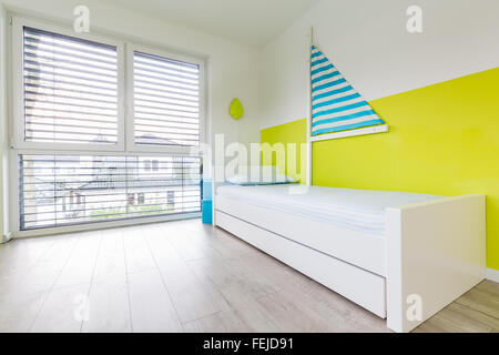 Im Kinderspielzimmer mit einem Bett ein großes Fenster anzeigen Stockfoto