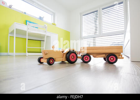 Bunten Kinderspielzimmer mit Schreibtisch und eine grüne Wand mit Spielzeug im Vordergrund Stockfoto