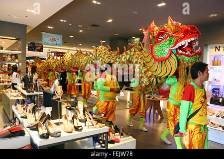 Bangkok, Thailand. 8. Februar 2016. Drachen bringt Glück für das chinesische Neujahr gehen überall in Bangkok, Thailand, einschließlich rund um die Shopping-Malls, sogar die Rolltreppen zwischen den Stockwerken zu reiten. Es war schon ein toller Anblick im Silom Complex Shopping Mall zu sehen, einen riesigen goldenen Drachen zu Fuß rund um die Kaufhäuser und eine Fahrt mit der Rolltreppe, im Jahr des Affen zu feiern und Geschenke aus dem Shop-Personal zu erhalten. Bildnachweis: Paul Brown/Alamy Live-Nachrichten Stockfoto