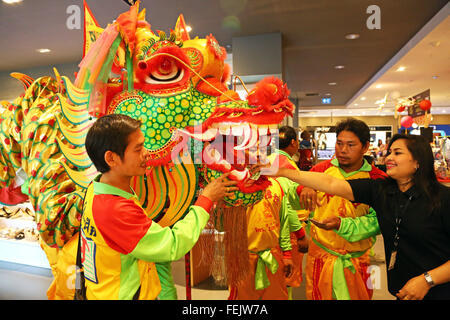 Bangkok, Thailand. 8. Februar 2016. Drachen bringt Glück für das chinesische Neujahr gehen überall in Bangkok, Thailand, einschließlich rund um die Shopping-Malls, sogar die Rolltreppen zwischen den Stockwerken zu reiten. Es war schon ein toller Anblick im Silom Complex Shopping Mall zu sehen, einen riesigen goldenen Drachen zu Fuß rund um die Kaufhäuser und eine Fahrt mit der Rolltreppe, im Jahr des Affen zu feiern und Geschenke aus dem Shop-Personal zu erhalten. Bildnachweis: Paul Brown/Alamy Live-Nachrichten Stockfoto