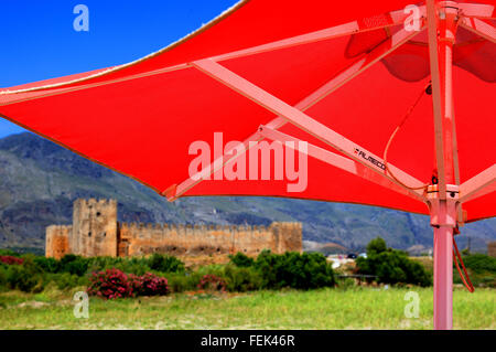 Kreta, rote Sonnenschirme und die Festung Frangokastello an der Südküste der Insel im Mittelmeer Stockfoto