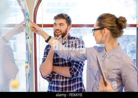 Lässige Geschäftsleute mit Whiteboard im Büro Stockfoto