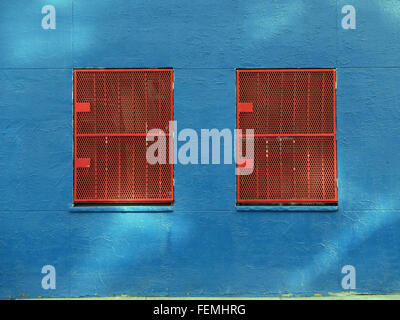 Zwei rote Fensterschirme auf einer blauen Wand in der Suffolk Street off Houston Street auf der Lower East Side von Manhattan, New York City Stockfoto