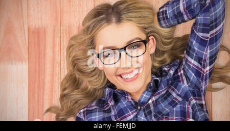 Zusammengesetztes Bild des Porträts von blonde Hipster auf dem Boden liegend Stockfoto