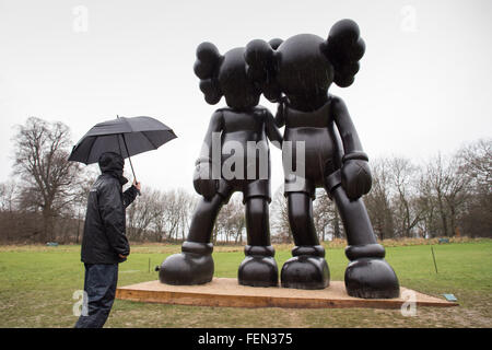 Wakefield, Yorkshire, Großbritannien. 8. Februar 2016. Ein Arbeiter sieht eine Skulptur mit dem Titel "Auf dem Weg" des amerikanischen Künstlers Brian Donnelly / KAWS, im nassen und windigen Zustand, zur Yorkshire Sculpture Park, in der Nähe von Wakefield, West Yorkshire, am 8. Februar 2016. Bildnachweis: Harry Whitehead/Alamy Live-Nachrichten Stockfoto