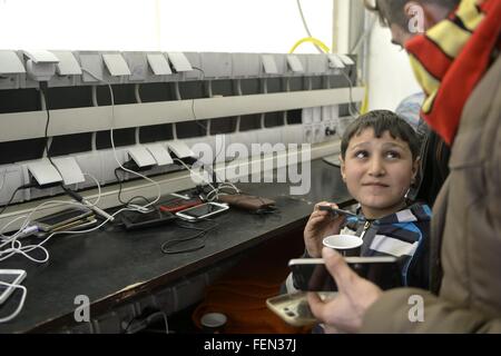 (160208)--GEVGELIJA, 8. Februar 2016 (Xinhua)--ein Flüchtling lädt seine Telefon in einem Flüchtlingslager in Gevgelija, mazedonische Süd Grenze zu Griechenland am 7. Februar 2016.  Mehr als tausend Migranten gehen über Mazedoniens Grenze jeden Tag, die meisten davon aus Syrien, Afghanistan und Irak sind. Mit der Unterstützung von UNHCR, die mazedonische Regierung und NGOs, unterstützen die Flüchtlingslager völlig kostenlos alles, was die Migranten Transit in Mazedonien, durch die Bereitstellung von Schlafmatten, decken, Zelte und Unterkunft Hallen, Nahrung, Getränke, WIFI, medizinische Betreuung, Hygieneartikel, sowie Beratung, Beratung in Bezug auf documentatio Stockfoto