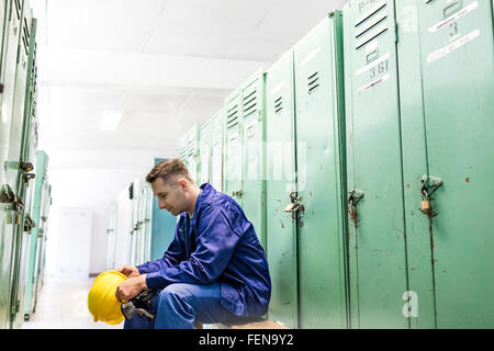 Arbeiter mit Schutzhelm in Umkleidekabine Stockfoto