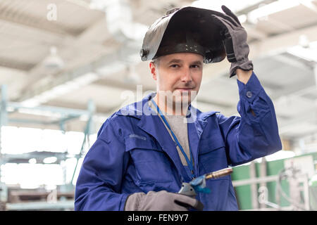 Porträt zuversichtlich Schweißer mit Schweißbrenner in Fabrik Stockfoto