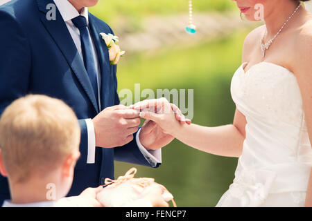 der Bräutigam Kleider nicht Gewicht einen Ring am Finger auf Hochzeit-Registrierung Stockfoto
