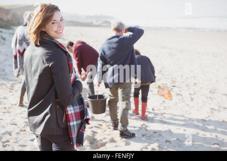 Lächelnde Frau Porträt Wandern am sonnigen Strand mit Familie Stockfoto