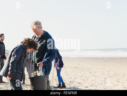 Generationsübergreifende Familie Clam Graben am Sonnenstrand Stockfoto
